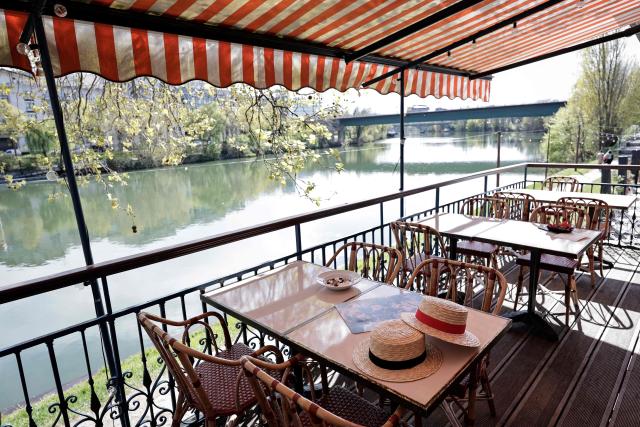 This photograph shows a boater hat displayed on the terrace where French impressionist Pierre-Auguste Renoir (1841-1919) created his painting "Luncheon of the Boating Party" (Le Dejeuner des Canotiers) at the Fournaise Museum on the Ile des Impressionnistes in Chatou, northwest Paris, on March 26, 2026. (Photo by STEPHANE DE SAKUTIN / AFP)