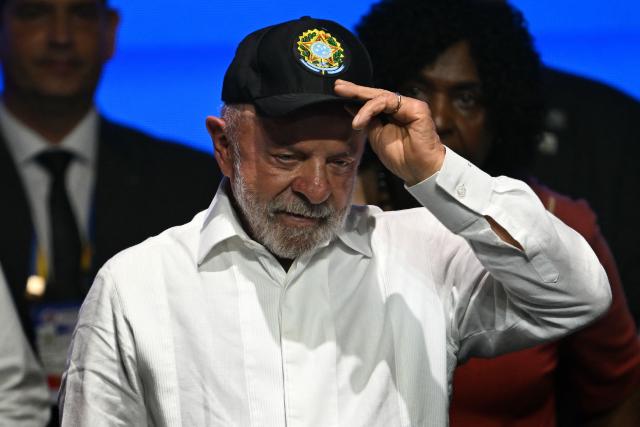 Brazil's President Luiz Inacio Lula da Silva puts a cap on during an event to announce investments as part of the Caravana Federativa program in Niteroi, Brazil, on March 26, 2026. (Photo by Mauro PIMENTEL / AFP)
