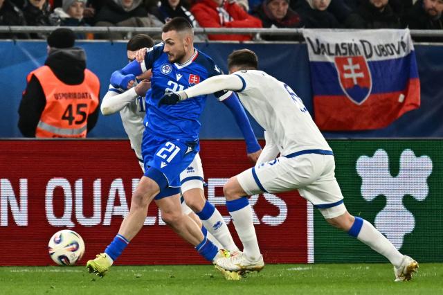 Kosovo's defender #19 Dion Gallapeni (L) and Kosovo's midfielder #06 Elvis Rexhbecaj vie for the ball with Slovakia's midfielder #21 Matus Bero (C) during the play-off 2026 FIFA World Cup European qualification semi-final football match between Slovakia and Kosovo in Bratislava on March 26, 2026. (Photo by Joe Klamar / AFP)