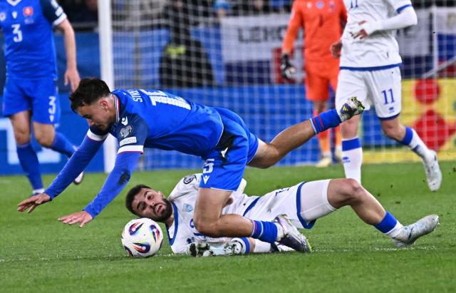 Slovakia's forward #15 David Strelec and Kosovo's defender #13 Kreshnik Hajrizi vie for the ball during the play-off 2026 FIFA World Cup European qualification semi-final football match between Slovakia and Kosovo in Bratislava on March 26, 2026. (Photo by Joe Klamar / AFP)