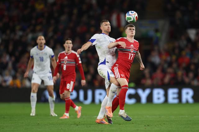 Wales' midfielder Jordan James is put under pressure by Bosnia-Herzegovina's forward Edin Dzeko  during the FIFA World Cup qualification semi-final football match between Wales and Bosnia and Herzegovina, at Cardiff City Stadium, in Cardiff, on March 26, 2026. (Photo by Darren Staples / AFP)