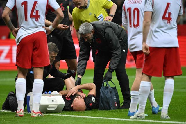 Albania's defender #05 Arlind Ajeti (C) receives medical treatment after an injury during the play-off FIFA World Cup 2026 European qualification semi-final football match between Poland and Albania in Warsaw on March 26, 2026. (Photo by Sergei GAPON / AFP)