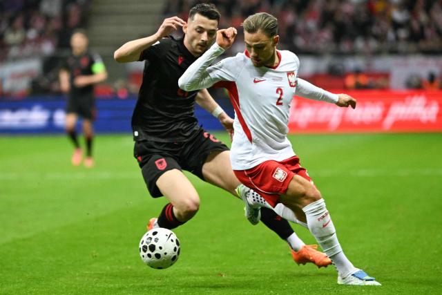 Poland's defender #02 Matty Cash (R) and Albania's forward #21 Arber Hoxha vie for the ball during the play-off FIFA World Cup 2026 European qualification semi-final football match between Poland and Albania in Warsaw on March 26, 2026. (Photo by Sergei GAPON / AFP)