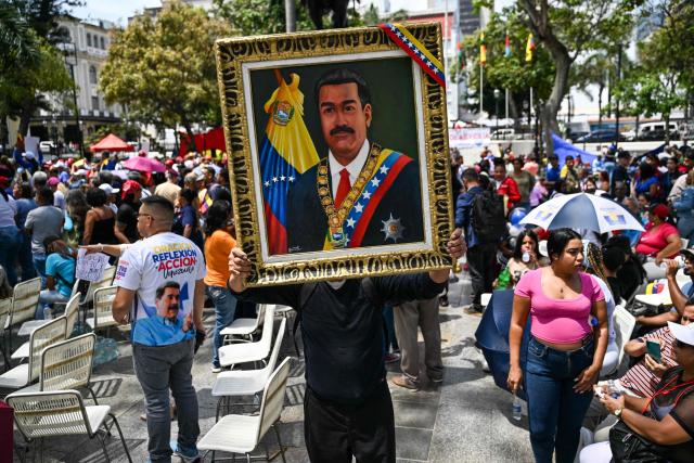 A supporter of Venezuela's ousted president Nicolas Maduro holds a painting depicting Maduro during a demonstration in Caracas on March 26, 2026, as he appeared in court in New York. Ousted Venezuelan president Nicolas Maduro was back in a New York court on March 26, 2026 for his second appearance since his capture by US forces in an extraordinary nighttime raid. (Photo by Juan BARRETO / AFP)