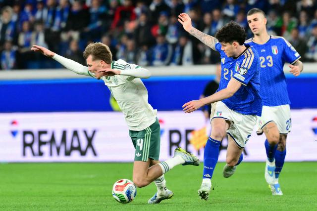 Northern Ireland's midfielder #14 Isaac Price fights for the ball with Italy's defender #21 Alessandro Bastoni during the play-off FIFA World Cup 2026 European qualification semi-final football match between Italy and North Ireland at the Gewiss stadium in Bergamo, on March 26, 2026. (Photo by Stefano RELLANDINI / AFP)