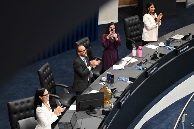 Deputies of the New Ideas party (L to R) Suecy Callejas, Congress president Ernesto Castro, Alexia Rivas and Elisa Rosales celebrate after the ratification of the constitutional reform to approve life imprisonment and extend the emergency regime to reach four years at the Legislative Assembly in San Salvador on March 26, 2026. (Photo by Marvin RECINOS / AFP)