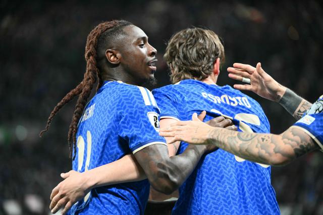 Italy's forward #11 Moise Kean (L) celebrates with teammates scoring his team's second goal during the play-off FIFA World Cup 2026 European qualification semi-final football match between Italy and North Ireland at the Gewiss stadium in Bergamo, on March 26, 2026. (Photo by Alberto PIZZOLI / AFP)