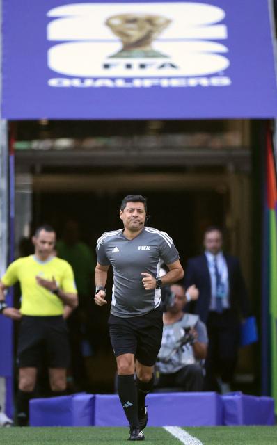 Iranian-Australian referee Alireza Faghani enters the field before the start of the 2026 FIFA World Cup qualifiers semi-final playoff football match between Bolivia and Suriname at the BBVA Stadium in Guadalupe, Mexico on March 26, 2026. (Photo by Julio Cesar AGUILAR / AFP)