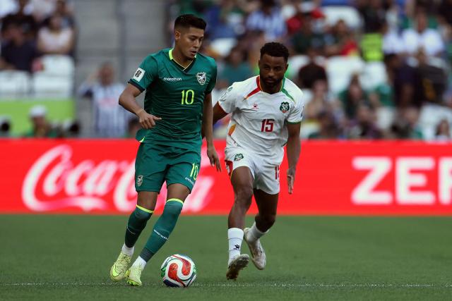Bolivia's forward #10 Ramiro Vaca and Suriname's defender #15 Djavan Anderson fight for the ball during the 2026 FIFA World Cup qualifiers semi-final playoff football match between Bolivia and Suriname at the BBVA Stadium in Guadalupe, Mexico on March 26, 2026. (Photo by Julio Cesar AGUILAR / AFP)