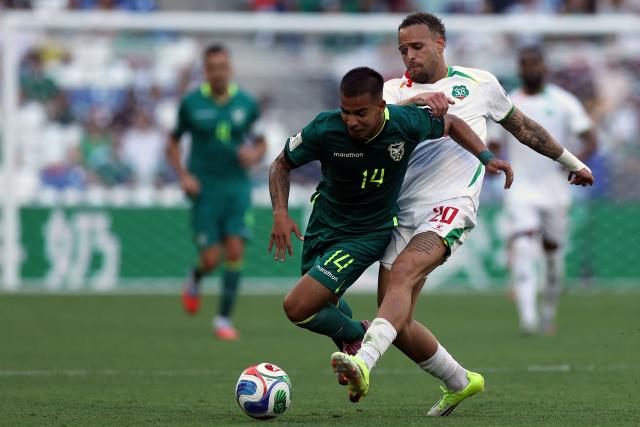 Bolivia's midfielder #14 Robson Matheus and Suriname's defender #20 Liam van Gelderen fight for the ball during the 2026 FIFA World Cup qualifiers semi-final playoff football match between Bolivia and Suriname at the BBVA Stadium in Guadalupe, Mexico on March 26, 2026. (Photo by Julio Cesar AGUILAR / AFP)