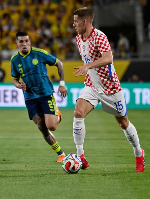 Croatia's midfielder #15 Mario Pasalic controls the ball followed by Colombia's midfielder #02 Daniel Munoz uring a friendly football match between Colombia and Croatia at Camping World Stadium in Orlando, Florida, on March 26, 2026. (Photo by Miguel J. Rodriguez CARRILLO / AFP)