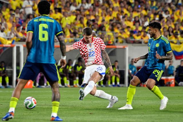 Croatia's defender #22 Luka Vuskovic shoots to score past Colombia's forward #24 Luis Suarez and Colombia's midfielder #06 Richard Rios during a friendly football match between Colombia and Croatia at Camping World Stadium in Orlando, Florida, on March 26, 2026. (Photo by Miguel J. Rodriguez CARRILLO / AFP)