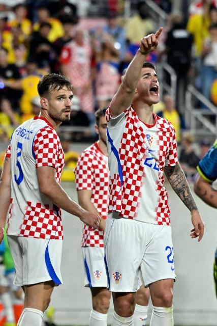 Croatia's defender #22 Luka Vuskovic (R) reacts as Croatia's defender #03 Marin Pongracic looks on during a friendly football match between Colombia and Croatia at Camping World Stadium in Orlando, Florida, on March 26, 2026. (Photo by Miguel J. Rodriguez CARRILLO / AFP)