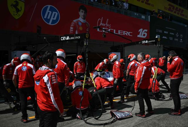 Mechanics work on the car of Ferrari's Monegasque driver Charles Leclerc before the first practice session of the Formula One Japanese Grand Prix in Suzuka, Mie prefecture on March 27, 2026. (Photo by Philip FONG / AFP)
