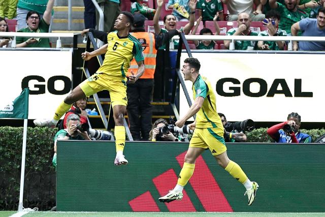 TOPSHOT - Jamaica's forward #09 Bailey Cadamarteri (R) celebrates with teammate defender #06 Richard King after scoring the opening goal during the 2026 FIFA World Cup qualifiers semi-final playoff football match between New Caledonia and Jamaica at the Akron Stadium in Zapopan, Mexico on March 26, 2026. (Photo by Ulises Ruiz / AFP)