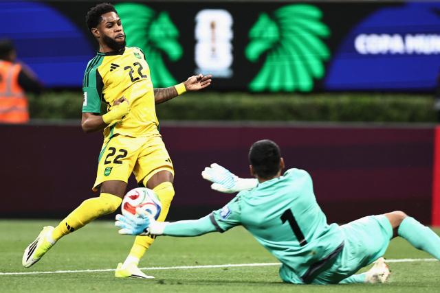 Jamaica's defender #22 Ronaldo Webster and New Caledonia's goalkeeper #01 Rocky Nyikeine fight for the ball during the 2026 FIFA World Cup qualifiers semi-final playoff football match between New Caledonia and Jamaica at the Akron Stadium in Zapopan, Mexico on March 26, 2026. (Photo by Ulises Ruiz / AFP)
