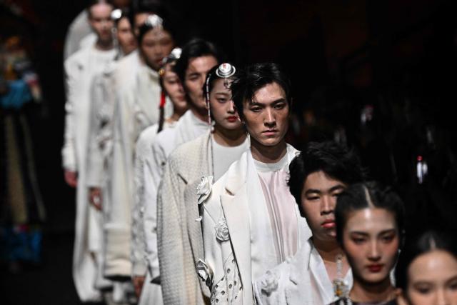 Models present creations by GRZG Rongrong Guo during the China Fashion Week in Beijing on March 26, 2026. (Photo by Pedro PARDO / AFP)