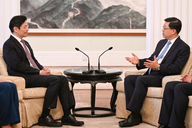 Hong Kong Chief Executive John Lee (R) and Singapore's Prime Minister Lawrence Wong (L) attend a meeting at Government House in Hong Kong on March 27, 2026. (Photo by Peter PARKS / POOL / AFP)