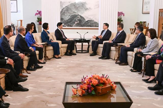Hong Kong Chief Executive John Lee (centre R) and Singapore's Prime Minister Lawrence Wong (centre L) attend a meeting at Government House in Hong Kong on March 27, 2026. (Photo by Peter PARKS / POOL / AFP)