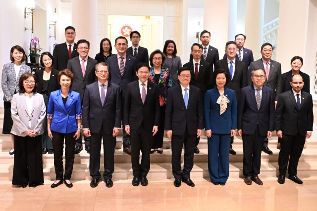 Hong Kong Chief Executive John Lee (front 4th R) and Singapore's Prime Minister Lawrence Wong (front 4th L) pose for a photo with their delegations at Government House in Hong Kong on March 27, 2026. (Photo by Peter PARKS / POOL / AFP)