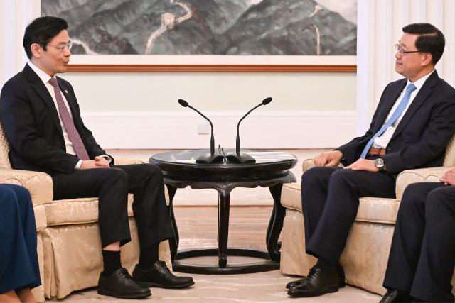 Hong Kong Chief Executive John Lee (R) and Singapore's Prime Minister Lawrence Wong (L) attend a meeting at Government House in Hong Kong on March 27, 2026. (Photo by Peter PARKS / POOL / AFP)