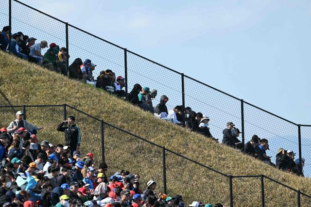Spectators wait for the start of the second practice session ahead of the Formula One Japanese Grand Prix at the Suzuka circuit in Suzuka, Mie prefecture on March 27, 2026. (Photo by ANDREW CABALLERO-REYNOLDS / AFP)