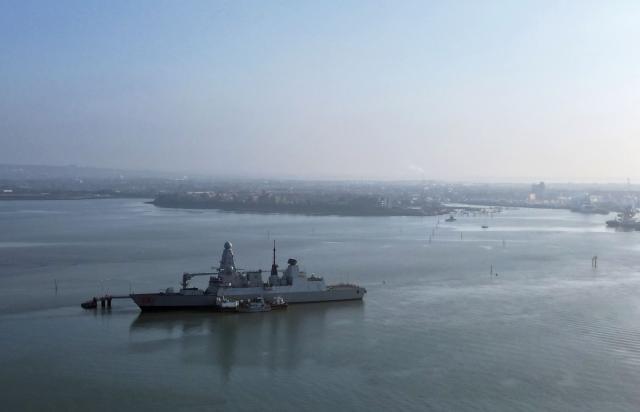 (FILES) An aerial view shows HMS Dragon, a Royal Navy Type 45 Daring-class air-defence destroyer warship, moored at the HMNB Portsmouth Upper Harbour Ammunition Facility (UHFC), outside HM Naval Base Portsmouth, pictured from Gosport, on the south coast of England, on March 4, 2026. The Middle East war, launched on 28 February, is exposing the limits of Britain's navy, seen as humiliating for a country long considered a historic maritime power. Controversy about Britain's naval capabilities first erupted over the late deployment of HMS Dragon to protect British bases in Cyprus, one of which was hit by an Iranian drone. The destroyer has only just arrived. In the meantime, France deployed its Charles de Gaulle aircraft carrier, while Italy and Greece sent ships to reassure Cyprus. Right-wing newspaper the Daily Telegraph called the comparisons "embarrassing". (Photo by JUSTIN TALLIS / AFP)