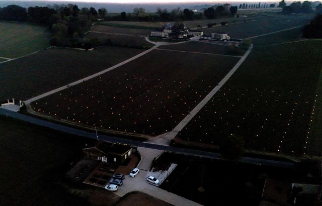 This aerial photograph shows anti-frost candles displayed in a vineyard to keep temperatures above zero degrees celsius and prevent vines from freezing, in Saint-Emilion, south-western France on March 27, 2026, as a cold wave hits the region. The announced frost episode during the night pushed winegrowers to take measures to protect their vines. (Photo by Christophe ARCHAMBAULT / AFP)