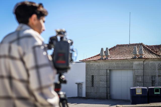 Journalists report in front of the entrance of the Prison in Guarda on March 27, 2026 where Cedric Prizzon, a former French police officer suspected of killing his partner and his ex-girlfriend after kidnapping them and their children, is detained. Prizzon, a one-time member of the Paris police and a former rugby league youth international, is also a fathers' rights activist who had been involved in a bitter public custody battle with his former partner. He had been stripped of his custody rights and had already been already convicted of harassing his former partner, after he illegally took their son to Spain for several weeks in 2021. (Photo by PATRICIA DE MELO MOREIRA / AFP)