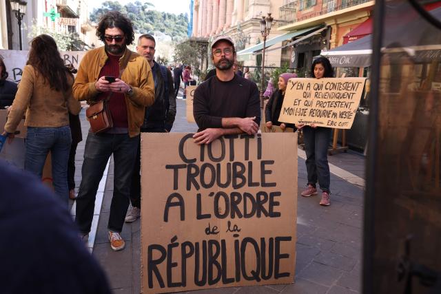 French farmer and activist Cedric Herrou holds a placard reading "Ciotti, an offence against the republic" during a demonstration held after the inaugural city council session in Nice on March 27, 2026. (Photo by Valery HACHE / AFP)