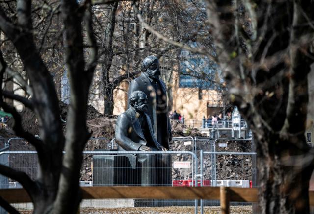 Statues of German philosophers and political theorists Karl Marx (L) and Friedrich Engels are surrounded by barriers and piles of rubble in Berlin on March 27, 2026, as embellishment work on the Marx-Engels forum continues. The statues, made by east German sculptor Ludwig Engelhardt were inaugurated in 1986 by then Communist leader Erich Honecker. (Photo by John MACDOUGALL / AFP)