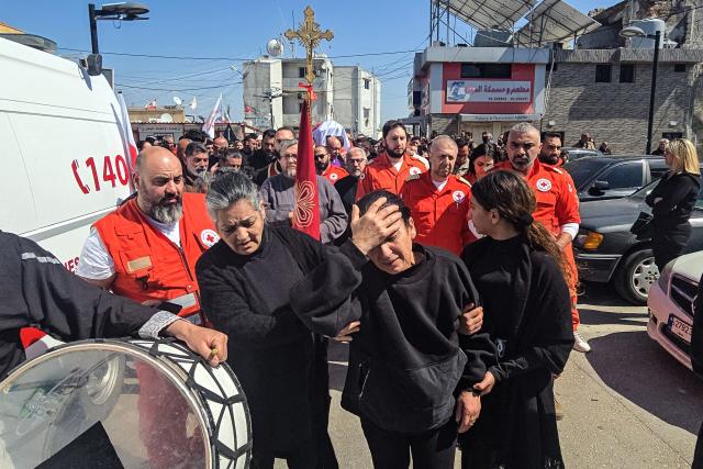 (FILES) Mourners attend the funeral of Youssef Assaf, a Lebanese Red Cross volunteer killed during a rescue mission in southern Lebanon, in Tyre on March 11, 2026. The United States and Israel began the war on February 28, 2026, by attacking Iran and killing its supreme leader. Iran retaliated with strikes against Israel and US allies and interests across the Gulf and Iraq, drawing the whole region into war. (Photo by Kawnat HAJU / AFP)