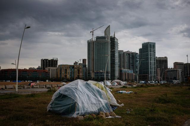 (FILES) This photograph shows tents of displaced families covered with plastic sheeting to shield them from stormy weather, erected along Beirut’s seafront area early on March 19, 2026. The United States and Israel began the war on February 28, 2026, by attacking Iran and killing its supreme leader. Iran retaliated with strikes against Israel and US allies and interests across the Gulf and Iraq, drawing the whole region into war. (Photo by DIMITAR DILKOFF / AFP)