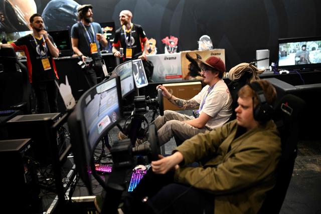 Gamers try out driving simulators during DreamHack 2026 at the NEC in Birmingham, central England on March 27, 2026. (Photo by Oli SCARFF / AFP)