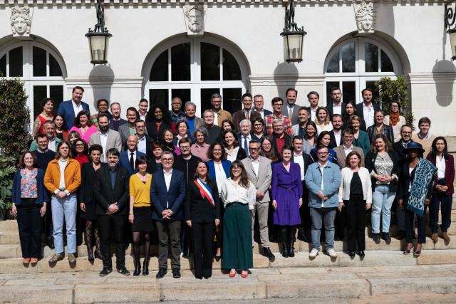 French socialist party (PS)  re-elected mayor of Nantes Johanna Rolland (C) poses with the new elected municipal council outside the town hall of Nantes, western France, on March 27, 2026. (Photo by Sebastien Salom-Gomis / AFP)