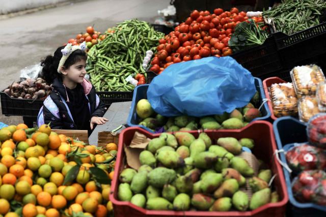 A Lebanese girl stands by a street vendor's stall in the Shayyah neighbourhood of Beirut's southern suburbs on March 27, 2026. Lebanon was drawn into the Middle East war on March 2 when Tehran-backed Hezbollah began firing rockets into Israel to avenge the killing of the Iranian supreme leader. Israel has since been bombing Lebanon, mainly in areas where Hezbollah has long held sway, and has sent in ground troops in a push to establish a buffer zone in south Lebanon. (Photo by ibrahim AMRO / AFP) / 