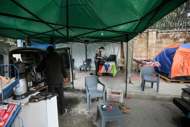 A street vendor selling coffee to displaced people from Beirut's southern suburbs stands at his stall near the Beirut Hippodrome on March 27, 2026. Lebanon was drawn into the Middle East war on March 2 when Tehran-backed Hezbollah began firing rockets into Israel to avenge the killing of the Iranian supreme leader. Israel has since been bombing Lebanon, mainly in areas where Hezbollah has long held sway, and has sent in ground troops in a push to establish a buffer zone in south Lebanon. (Photo by ibrahim AMRO / AFP)