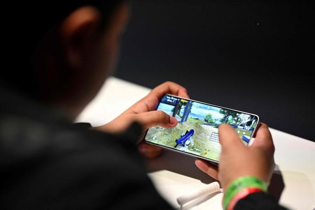 A person plays a mobile game during DreamHack 2026 at the NEC in Birmingham, central England on March 27, 2026. (Photo by Oli SCARFF / AFP)