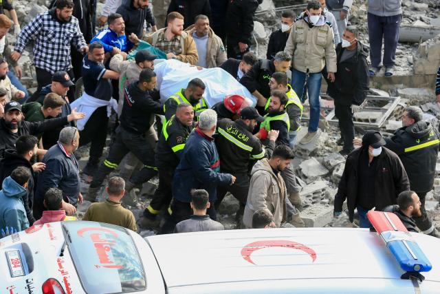 First aid responders carry a body from the site of an Israeli aistrike that targeted a building in the southern Lenanese village of Sarafand on March 27, 2026. Hezbollah said on March 27 its fighters had clashed directly with Israeli forces in two south Lebanon villages, as Israeli airstrikes across the region killed at least six people, according to the health ministry. Lebanon was pulled into the Middle East war when Tehran-backed militant group Hezbollah fired rockets towards Israel on March 2 to avenge the US-Israeli killing of Iran's supreme leader Ayatollah Ali Khamenei. (Photo by AFP) / 