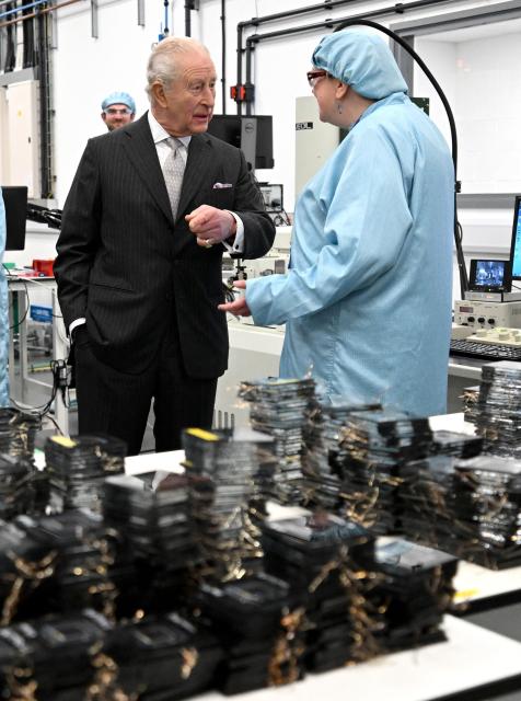 Britain's King Charles III speaks with a staff member during a visit to Oxford Photovoltaics an enterprise developing advanced solar panels, in Kidlington, Oxfordshire, west of London on March 27, 2026. (Photo by Kate Green / POOL / AFP)