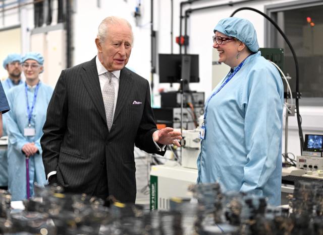 Britain's King Charles III speaks with a staff member during a visit to Oxford Photovoltaics an enterprise developing advanced solar panels, in Kidlington, Oxfordshire, west of London on March 27, 2026. (Photo by Kate Green / POOL / AFP)