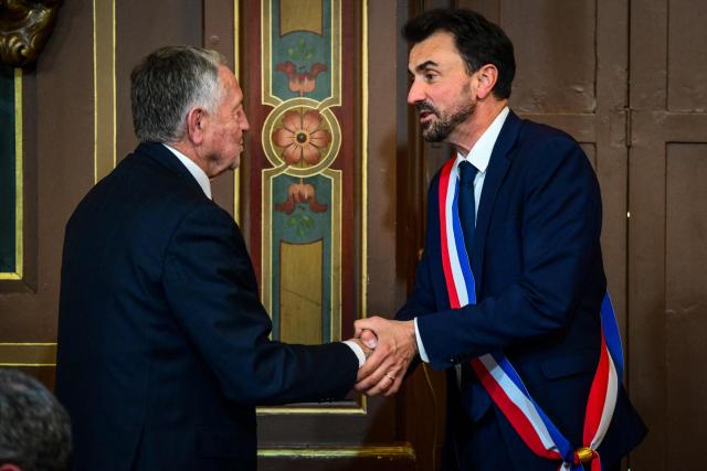 Newly re-elected Lyon mayor Gregory Doucet (R) receives his mayoral sash from Jean-Michel Aulas, vice-president of the French Football Federation (FFF), during the inaugural session of the city council, central-eastern France, on March 27, 2026. (Photo by OLIVIER CHASSIGNOLE / AFP)