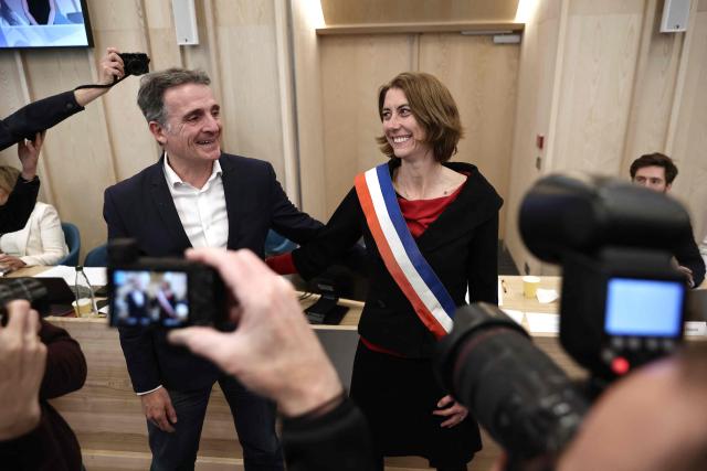 Grenoble's new Mayor Laurence Ruffin (R) of the left-wing and ecologist alliance reacts with Grenoble's outgoing mayor Eric Piolle during the inaugural meeting of the new municipal council at the city hall of Grenoble, central-eastern France, on March 27, 2026. (Photo by Maxime Gruss / AFP)