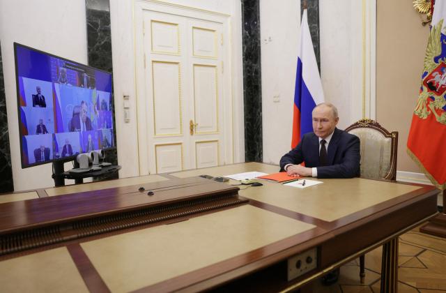 In this pool photograph distributed by the Russian state agency Sputnik, Russia's President Vladimir Putin holds an operational meeting with permanent members of the Security Council of the Russian Federation via videoconference in Moscow on March 27, 2026. (Photo by Gavriil Grigorov / POOL / AFP)