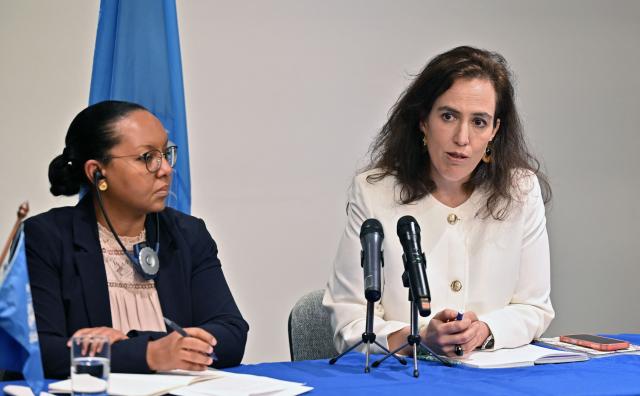 Joana de Deus Pereira (R), member of the United Nations working group against the use of mercenaries speaks as its president Michelle Small listens during a press conference to present a report in Bogota on March 27, 2026. (Photo by Daniel MUNOZ / AFP)