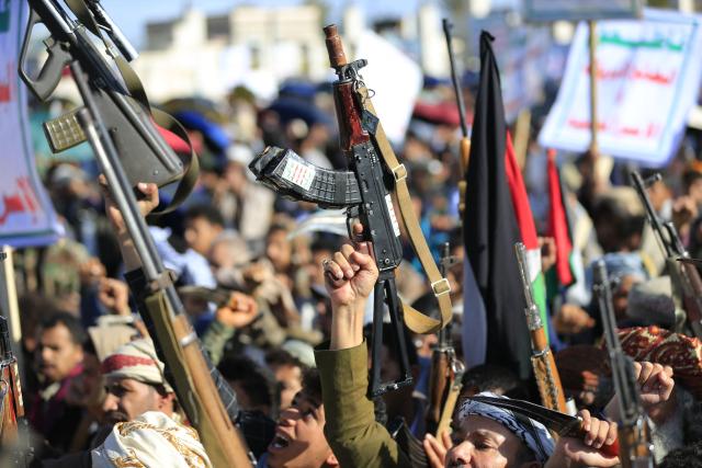 Houthis brandish their weapons as they rally in solidarity with Iran and Lebanon, amid the US-Israeli war with Iran, in the Yemeni capital Sanaa on March 27, 2026. Abdul Malik al-Houthi, leader of Yemen's Iran-backed Houthi movement, warned on March 26 of a "military response" should the Middle East war require it. The Houthis, a key part of Iran's so-called "axis of resistance", have so far refrained from joining the war sparked by US-Israeli strikes on Iran, which has engulfed much of the region. (Photo by Mohammed HUWAIS / AFP)