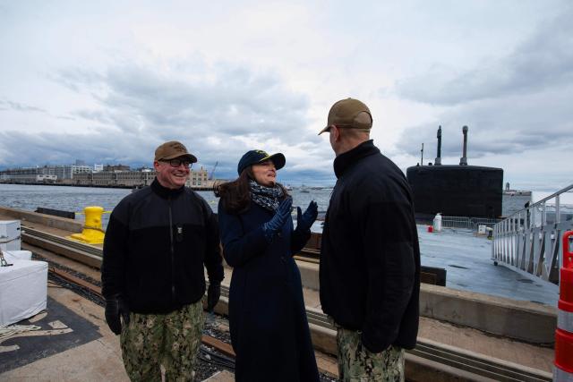 Master Chief Edward Brennan (L) looks on as philanthropist, tech executive and ship sponsor Sheryl Sandberg and ship commander Mike Siedsma (R) chat outside the Virginia-class fast attack submarine USS Massachusetts (SSN 798) as it sits docked at the Conley Container Terminal before her commissioning ceremony in Boston, Massachusetts, on March 27, 2026. The US Navy will commission the Virginia-class fast attack submarine during a ceremony on March 28. (Photo by Joseph Prezioso / AFP)