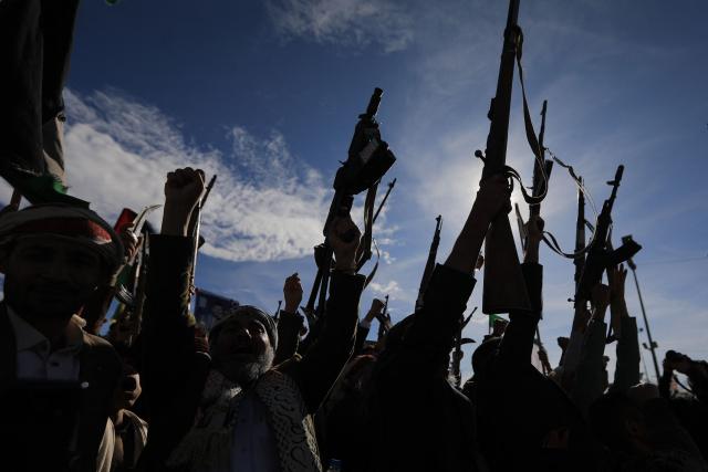 Houthis brandish their weapons as they rally in solidarity with Iran and Lebanon, amid the US-Israeli war with Iran, in the Yemeni capital Sanaa on March 27, 2026. Abdul Malik al-Houthi, leader of Yemen's Iran-backed Houthi movement, warned on March 26 of a "military response" should the Middle East war require it. The Houthis, a key part of Iran's so-called "axis of resistance", have so far refrained from joining the war sparked by US-Israeli strikes on Iran, which has engulfed much of the region. (Photo by Mohammed HUWAIS / AFP)
