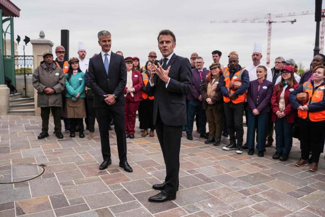 French President Emmanuel Macron (C) delivers a speech flanked by Chairman of Disney parks Josh D'Amaro (L) during the inauguration of the new Disney Adventure World theme 'World of Frozen' at Disneyland Paris in Marne-la-Vallee, east of Paris, on March 27, 2026. (Photo by Thibault Camus / POOL / AFP)