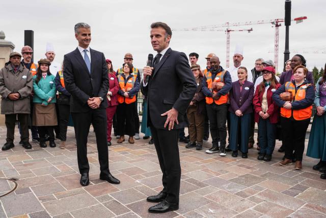 French President Emmanuel Macron (C) delivers a speech flanked by Chairman of Disney parks Josh D'Amaro (L) during the inauguration of the new Disney Adventure World theme 'World of Frozen' at Disneyland Paris in Marne-la-Vallee, east of Paris, on March 27, 2026. (Photo by Thibault Camus / POOL / AFP)